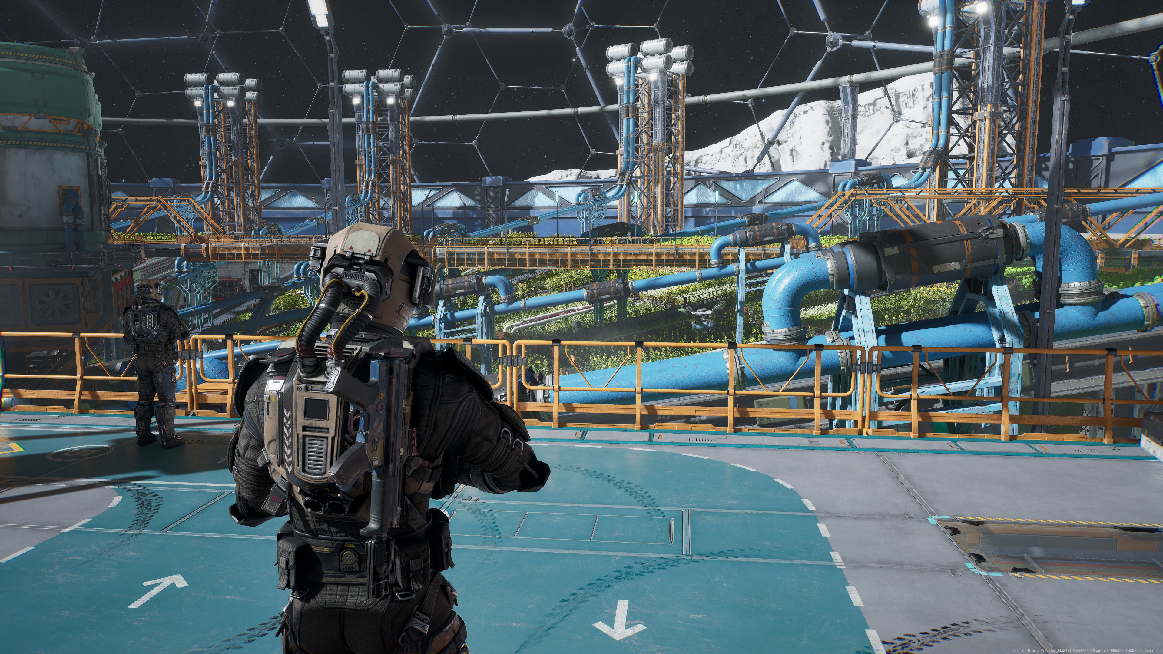 A suited man stands on a platform, with a big building behind him